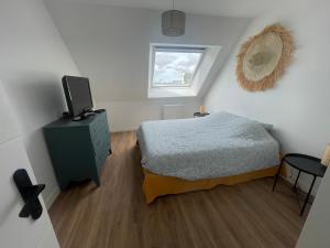 a bedroom with a bed and a television in it at Maison 5 chambres sortie saint malo in Saint-Méloir-des-Ondes