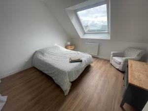 a bedroom with a bed and a window and a chair at Maison 5 chambres sortie saint malo in Saint-Méloir-des-Ondes