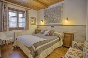 a bedroom with a bed and a chair at San Marsial Benasque Apart Hotel in Benasque