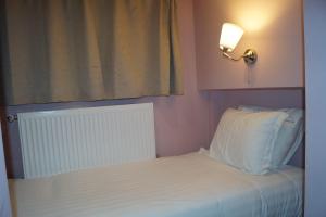 a bedroom with a white bed with a window at EU Guesthouse in Brussels