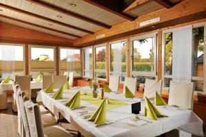 a dining room with tables and chairs and windows at Hotel Dreimädelhaus in Espelkamp-Mittwald
