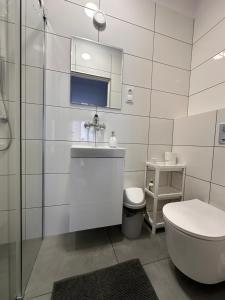 a white bathroom with a toilet and a sink at Relax in Ostrowo +69 photos