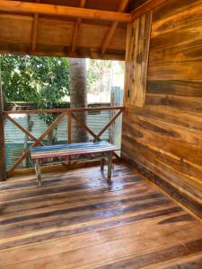 a bench on the porch of a log cabin at River Point in Pottuvil