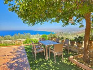 a table and chairs under a tree with a view at Villa Balcony, Cozy Villa with Amazing View in Rodia