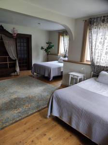 a bedroom with two beds and a rug at Forest apartment in the loop of the river Neris in Verkšonys