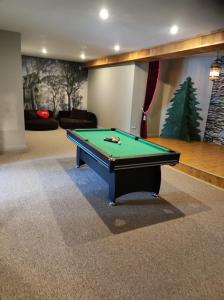 a billiard table in a living room with at Forest apartment in the loop of the river Neris in Verkšonys