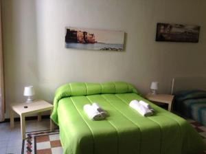 a green bed in a room with two tables at O Sarracino B&B in Naples