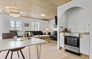 a kitchen and living room with a table and a stove at Holiday Home Strandvejen Brovst Denm in Brovst