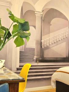 a bedroom with a staircase and a table and a plant at Daily Napoli - Lungomare in Naples