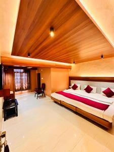 a bedroom with a large bed and a wooden ceiling at Hotel City Palace in Ooty