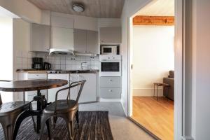 Una cocina con gabinetes blancos y una mesa y sillas. en Cozy apartment in the heart of Visby, en Visby