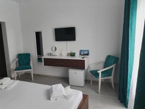 a room with two beds and a desk and two chairs at Pensiunea Prigoria in Murighiol