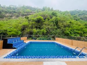 a swimming pool on top of a resort with trees at Shri Shyam Hotel, Near Harkipauri in Haridwār