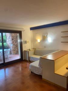 un soggiorno con un divano e un tavolo di Residence Portorotondo Asfodeli a Porto Rotondo Altre 129 foto
