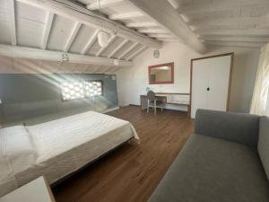 a large bedroom with a bed and a couch at La Vecchia cantina Guzzardi in Lari +39 photos