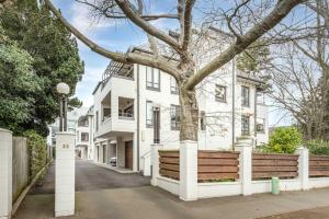 a white house with a tree in front of it at Heart of Christchurch in Christchurch