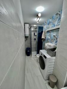 a bathroom with a shower and a washing machine at A'MARE da Marco Loft in Sperlonga