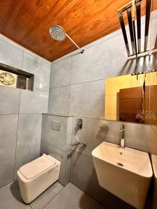 a bathroom with a white toilet and a sink at Hotel City Palace in Ooty