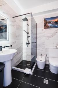 a bathroom with a shower and a sink and a toilet at Saranda Terraces Exclusive Appartment in Sarandë +68 photos