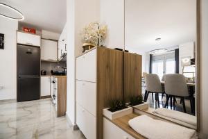 a kitchen and dining room with a refrigerator and a table at Saranda Terraces Exclusive Appartment in Sarandë