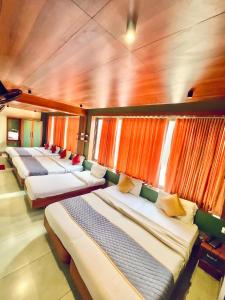 a row of beds in a room with windows at Hotel City Palace in Ooty