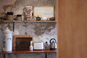 a shelf with a microwave and a toaster on it at The Book Shop in Robe