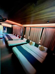 a row of beds in a room with windows at Hotel City Palace in Ooty