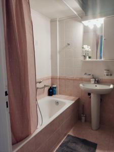 a bathroom with a bath tub and a sink at Los Laureles Relaxing Vintage Home in Sparti +14 photos