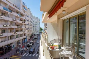 a balcony with chairs and a view of a street at T3Appartement de luxe Croisette en face de la plage Martinez 80m2 in Cannes