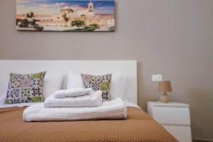 a pile of towels sitting on top of a bed at Casa vacanze Casuzza Sferracavallo Palermo in Palermo +40 photos