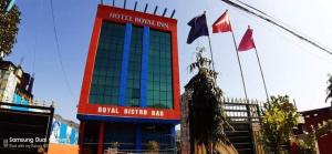 Trisūli BāzārHotel Royal Inn Batar的一间挂着旗帜的酒店房间