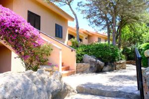a building with purple flowers on the side of it at Porto Rotondo home with Pool access & Sea Views in Porto Rotondo