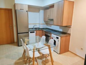 a kitchen with a table and chairs and a refrigerator at Terraza acogedora , Piscina , Parking, Airé Acondicionado in El Campello