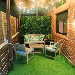 a patio with two chairs and a bench and a hedge at Terraza acogedora , Piscina , Parking, Aire Acondicionado, in El Campello +8 photos