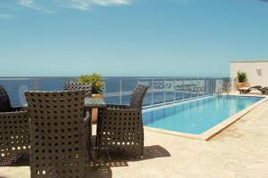 a patio with a table and chairs and a swimming pool at Paradise beachfront view 2 in Dobra Voda