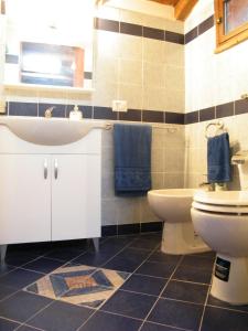 a bathroom with a sink toilet and blue towels at Casa vacanze San Giorgio in Alcara li Fusi