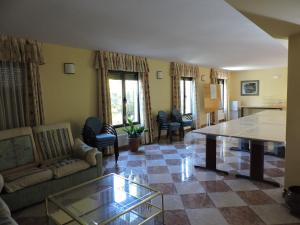 a living room with a couch and a table at Hostal Mirasierra in Bustarviejo