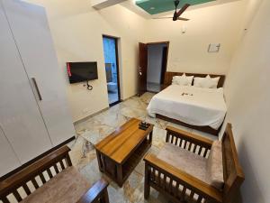 Un dormitorio con una cama y un televisor. en Olive Residence, Near Lakeshore Hospital, en Kochi