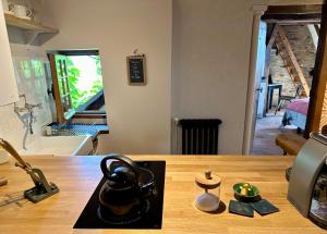 a kitchen counter with a tea kettle on a table at Le Petit Tinténiac - T2 cosy au cœur de la Doutre in Angers +22 photos