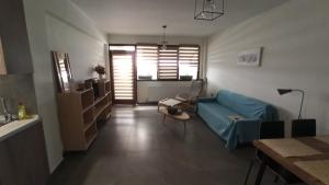 a living room with a blue couch and a table at Coralia's House in Nea Moudania