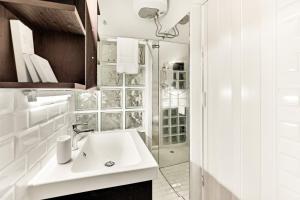 a white bathroom with a sink and a shower at DUOMO - Bright Gateway Downtown in Milan +14 photos
