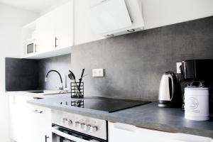 eine Küche mit weißen Schränken und einer schwarzen Arbeitsplatte in der Unterkunft SH Team Lodges 4 Apartments für max 19 Personen l Monteure l Messe l Business in Duisburg