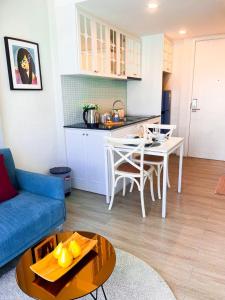 a living room with a blue couch and a table at Exclusive condo & Seaview in Ban Bang Saen (1) +3 photos