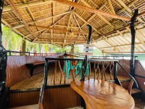 a boat with two wooden tables and a roof at Binucot Lodge in Romblon