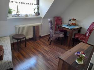 a living room with a dining room table and chairs at Pension Entenhausen in Schwentinental