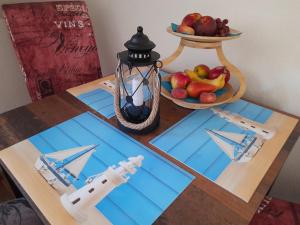 a table with a model of a boat and a bowl of fruit at Pension Entenhausen in Schwentinental