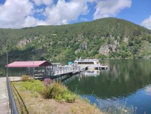 a boat is docked at a dock on a lake at O Recuncho da Isa - Ribeira Sacra in Pereiro de Aguiar
