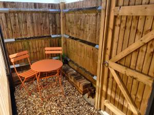 a patio with a table and two chairs and a fence at Pentagram Studio in Lewes