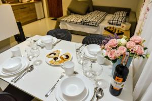 una mesa con platos y una botella de vino y flores en Skorzęcin Pachnie Miętą, en Skorzęcin