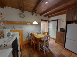 a kitchen with a table and chairs in a kitchen at O Recuncho da Isa - Ribeira Sacra in Pereiro de Aguiar